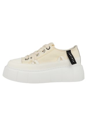 Beige lavtop sneaker med tyk hvid platformsål, brede snørebånd, metaløjer og sort branded stof trækkeøs bag på hælen.