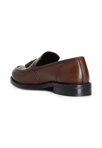 Hnědé kožené loafers s kulatou špičkou, plochou černou podrážkou a dekorativními třásněmi na přední části. Hladký povrch s minimem švů.