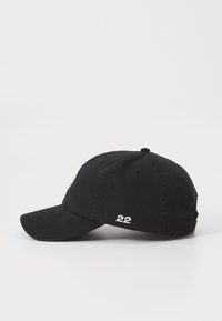Casquette en coton noir avec une visière courbée, présentant le numéro "22" brodé en blanc à l'avant et des trous de ventilation sur la couronne.