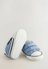 Zilas kanvas apavus ar āķa un cilpas siksnām, baltu gumijas zoli un pirkstu aizsargiem, uz siksnām drukāts "BAKER 2026". Strukturēta zole.