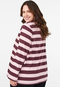 Svītrains garām piedurknēm tops tumši sarkanā un maigi rozā krāsā. Raksturīga brīva piegriezuma forma, apaļš izgriezums un mīksta džersija.