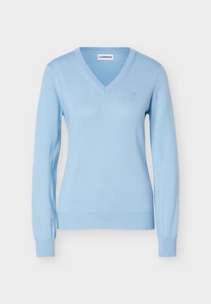 Gaiši zils garroku džemperis ar V-veida izgriezumu, ribainiem aprocēm un apakšmalu, kā arī smalku zīmola logotipu uz krūtīm.