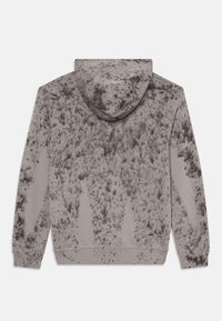 Felpa grigia con cappuccio, caratterizzata da un motivo testurizzato di macchie più scure, con cappuccio regolabile e polsini e orlo a coste. Tessuto morbido, design unisex.