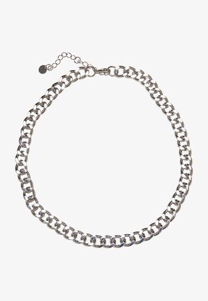 Sidabrinės spalvos metalo grandinėlė su dideliais tarpusavyje susijungiančiais žiedais ir reguliuojamu užsegimu su mažuoju žymeniu. Lygus, blizgus paviršius.