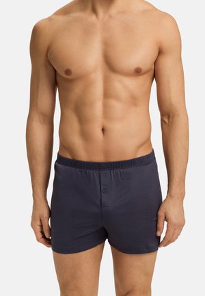 Boxers en coton bleu marine pour hommes avec une texture douce, une ceinture élastique et une fermeture à bouton à l'avant.