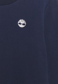 Dunkelblaue Sweatshirt mit rundem Ausschnitt, versehen mit einem weißen gestickten Baumlogo auf der Brust in einem kreisförmigen Design. Glatte Textur.