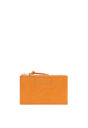 Orange crocodile-embossed wallet with a zip closure and a wrist strap. Features a gold embossed logo on the front.