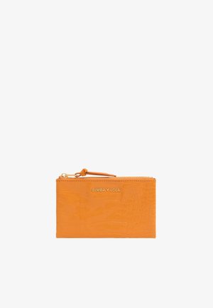 Peňaženka v oranžovej farbe s embosovaním krokodíla, so zipsovým uzáverom a remienkom na zápästie. Na prednej strane sa nachádza zlatý embosovaný logo.