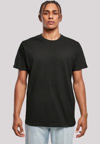 Juodas medvilnės T-shirt, trumpomis rankovėmis, su apvaliu iškirpimu, laisvas kirpimas. Lygi tekstūra be matomų raštų ar akcentų.