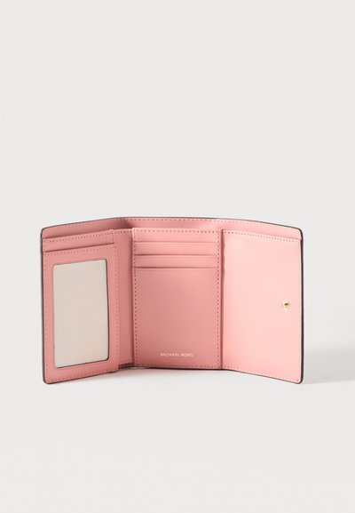 Portefeuille en cuir rose à trois volets ouvert montrant des fentes pour cartes, une fenêtre d'identité transparente et le logo doré "Michael Kors" sur fond blanc.