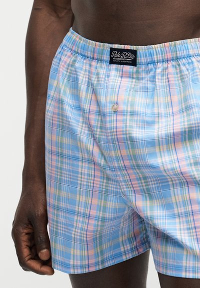 Ενήλικας που φοράει βαμβακερά μποξεράκια σε καρό μοτίβο με αποχρώσεις γαλάζιου, ροζ και πράσινου, με ετικέτα Polo Ralph Lauren στη λαστιχένια μέση.