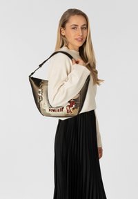 Schultertasche aus schwarzem Leder mit einem grafischen Design, das eine Frau, den Schriftzug "Love Yourself", goldene Akzente und eine Kettendetail aufweist.