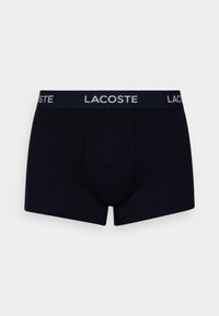 Fekete pamut boxer alsónadrág, testhez álló fazonban, puha derékkal, amelyen fehér "LACOSTE" logó található. Sima textúrájú, minták nélkül.