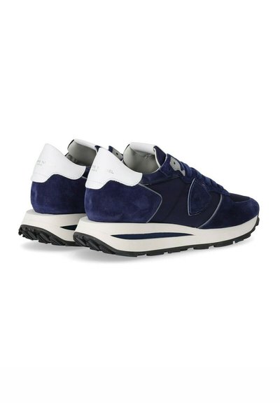 Sneaker blue scamosciato con tallone bianco, upper in blu navy testurizzato, dettagli tonali e suola in gomma a contrasto, con colletto imbottito e lacci.