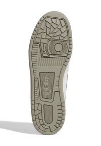 Podeszwa buta w kolorze beżowym i jasnoszarym z teksturowanym wzorem antypoślizgowym, z okrągłym akcentem i logo "adidas" po stronie bocznej.