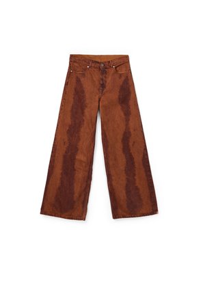 Jeans a gamba larga color ruggine con motivi verticali più scuri effetto acid wash, chiusura frontale con bottoni e design a cinque tasche, distesi su uno sfondo bianco.