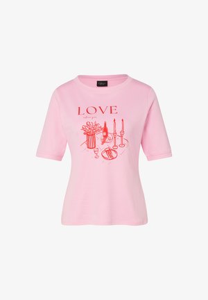 Różowa koszula z krótkim rękawem z czerwonym nadrukiem kwiatów w wazonie, butelki wina, kieliszka, chleba, świec i napisem "LOVE" nad wzorem.