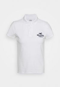 Weißes Poloshirt aus Baumwolle mit Kragen, kurzen Ärmeln und einem navyblauen gestickten "Hollister California"-Logo auf der Brust.