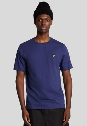 T-shirt di cotone blu navy con scollatura a girocollo e maniche corte. Presenta un piccolo logo giallo sul lato sinistro del petto. Texture liscia.