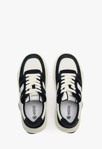 Czarne i kremowe sneakersy charakteryzują się gładkim cholewką ze skóry i zamszu, okrągłym noskiem, płaskimi białymi sznurówkami oraz amortyzowaną podeszwą z teksturowanymi akcentami.