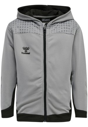 Haut à capuche zippé gris avec des accents noirs, présentant une texture à pois sur les épaules, une doublure en mesh et le logo "hummel" sur la poitrine.