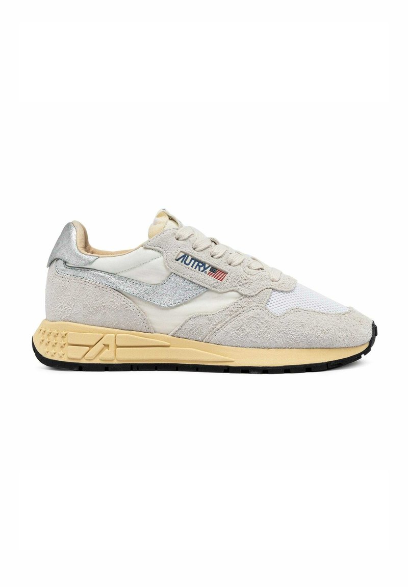 Sneakers beige e grigie con una combinazione di materiali in pelle scamosciata e mesh, design con lacci e suola in gomma strutturata con dettagli accentuati.