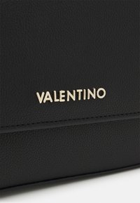 Sort lædertaske med en struktureret overflade og prægede guld "Valentino" logo detaljer på fronten.