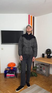 Čierna a sivá vystužená bunda s vysokým golierom, s kontrastnou čiernou časťou na pleciach, zapínaním na gombíky a elastickými manžetami.