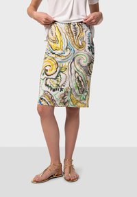 Jupe crayon à motif floral en tissu léger, avec des motifs tourbillonnants jaunes, verts et gris. Longueur genou avec une silhouette ajustée.