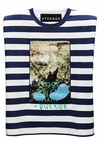 T-shirt a righe navy e bianco con una grafica quadrata che presenta galline e il testo: "uova", "latte di soia al cioccolato" e "burro" in verde e blu.