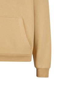 Manche et poche avant de sweat-shirt beige avec poignets et ourlet côtelés en tissu de coton doux.