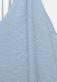 Tissu bleu clair à texture fine, montrant une partie d'un vêtement sans manches avec de fines bretelles.