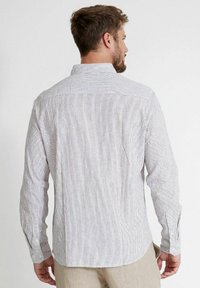 Hátulnézet egy hosszú ujjú ingről, világosszürke és fehér függőleges csíkokkal, gombos mandzsettákkal és gallérral, puha anyagból készült.