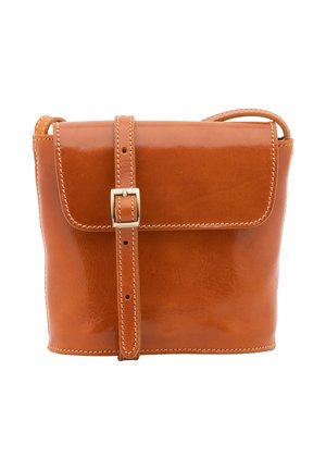 Petit sac bandoulière en cuir marron avec fermeture à boucle et coutures apparentes sur le rabat et la sangle, sur fond blanc.