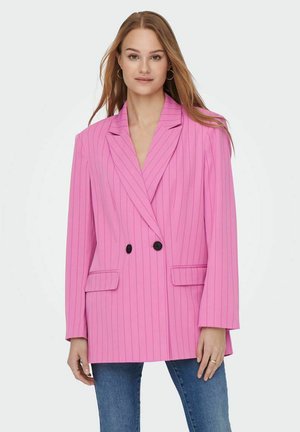 Blazer rosa a righe con doppio petto, revers a punta, due tasche frontali e bottoni neri. Indossato sopra jeans blu.