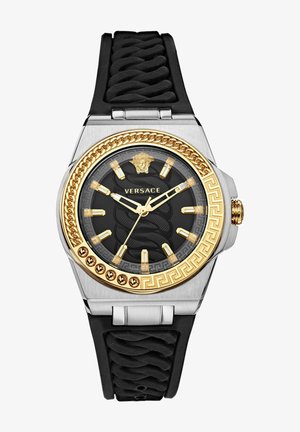 Versace watch with black rubber strap, silver case, gold accents, textured black dial featuring lion emblem and Greek key pattern.