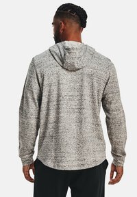 Grauer und schwarzer, gesprenkelter Hoodie mit langen Ärmeln, einer Kapuze mit Kordelzug und einem abgerundeten Saum, getragen von einer Person, die von hinten betrachtet wird.