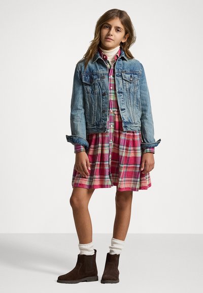 Denim jakna s bademirovimi žepi, čez roza karo obleko. Rjave gležnjarje in bele nogavice dopolnjujejo videz.