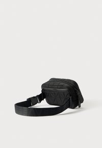 Borsa in vita nera trapuntata con un motivo geometrico, dotata di un scomparto principale con zip e tracolla regolabile, realizzata in tessuto resistente.