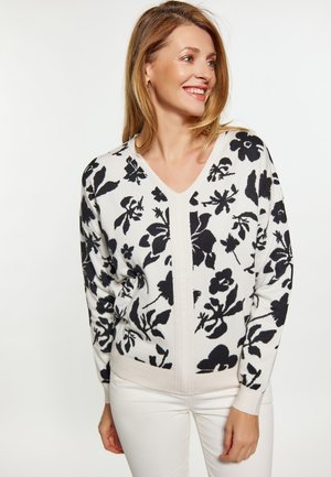 Cardigan cu decolteu în V, din țesătură albă cu un model floral negru, având mâneci lungi și detalii nervurate pe margini și pe clapeta frontală.