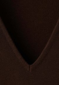 Gros plan d'un tissu tricoté marron foncé avec un col côtelé en V, montrant une texture fine et des détails de couture.