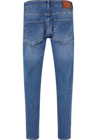 Jeans en denim bleu avec une coupe slim, un design à cinq poches, un patch en cuir sur la ceinture, et une décoloration minimale à la surface.