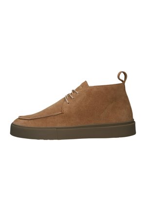 Zapatos altos de ante marrón con puntera redonda, cordones en el frente y una pestaña en la parte trasera. Suela de goma gruesa que añade tracción y soporte.