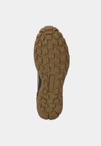 Semelle de chaussure en caoutchouc avec des crampons profonds, présentant une finition sombre et des accents brun clair. Surface texturée pour une meilleure adhérence.