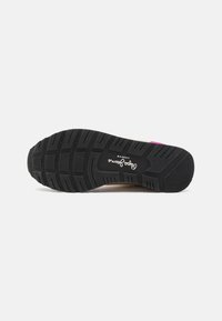 Semelle de chaussure en caoutchouc noir avec des rainures profondes, un section médiane lisse et un logo blanc. La forme globale est rembourrée et ergonomique.
