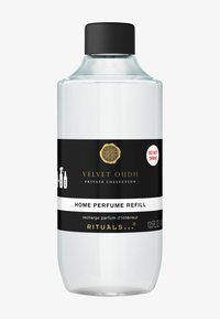 Bottiglia di vetro trasparente con tappo nero. Presenta un'etichetta in bianco e nero con dettagli dorati, che indica "Ricarica di Profumo per Ambienti Velvet Oudh".