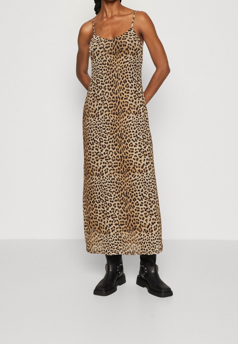 Maxiklänning med leopardmönster, smala axelband, slät tyg och rak skärning. Bärs med svarta ankelboots med spänne.