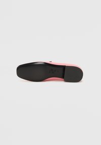 Sapato de salto rosa com um cabedal liso e sola preta brilhante. O salto é afunilado e apresenta um design minimalista, sem adornos.