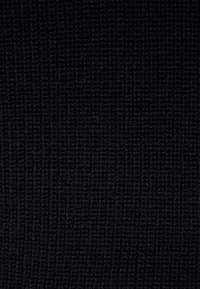 Tissu noir texturé avec un motif côtelé, présentant un tissage serré qui révèle des détails fins et une finition lisse.