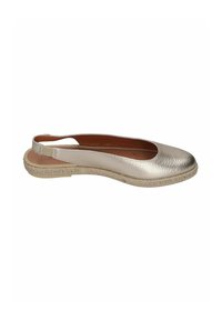Zapato plano metálico plateado con punta redonda, parte superior de cuero y suela envuelta en yute. Tiene un diseño de tirante trasero para un ajuste seguro.